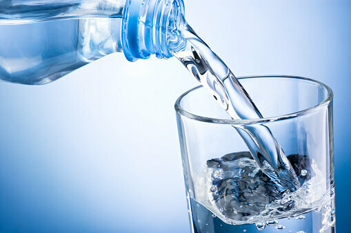 Наполнение стакана из пластиковой бутылки воды