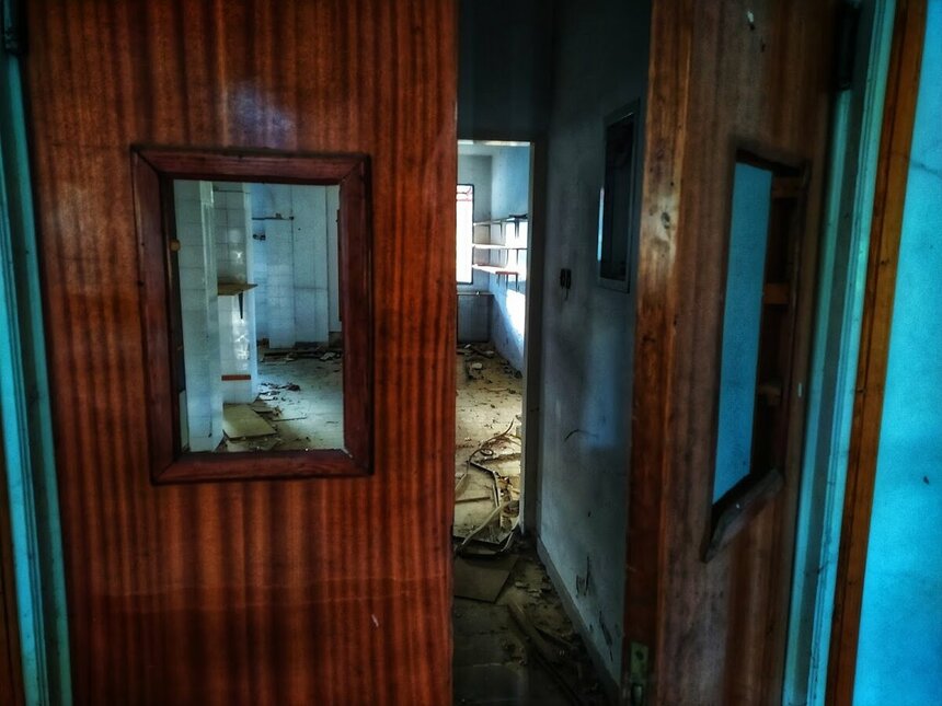 Дверь на кухню в заброшенном отеле