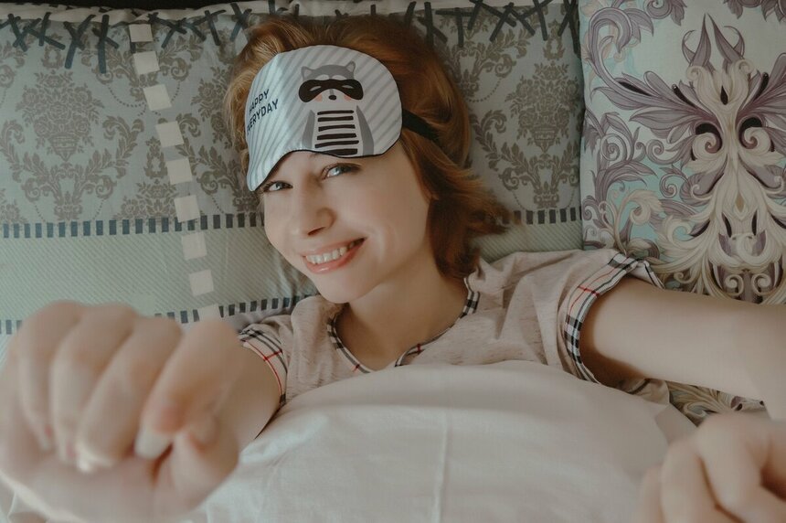Девушка лежит в кровати, выше глаз у неё находится специальная маска, чтобы спать при свете - Victoria_Borodinova