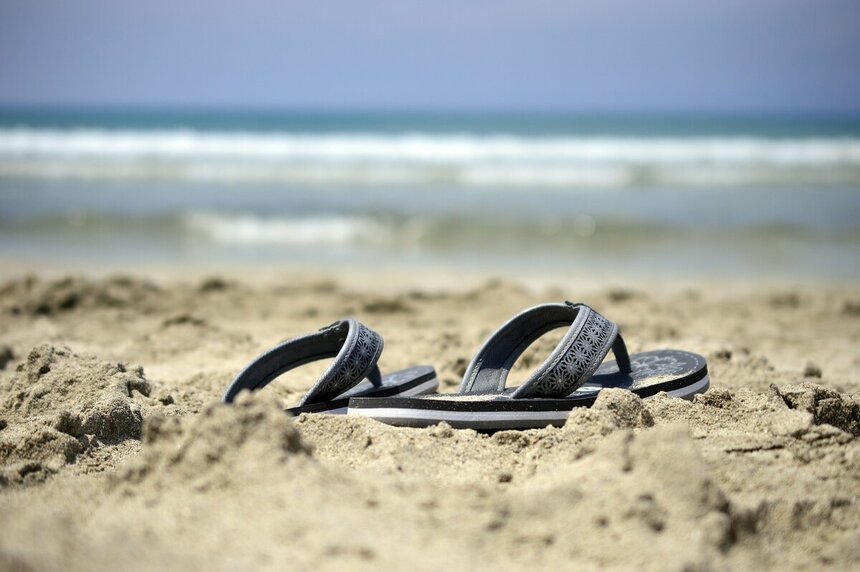 Сандали лежат в песке возле кромки моря - Peggychoucair