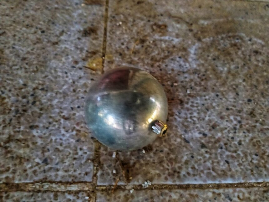 Грязный новогодний шарик на полу в гостинице