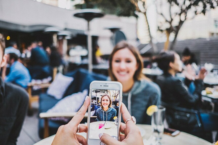 Одна женщина фотографирует другую на телефон - Pexels