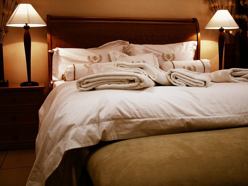 КроваЗаправленная кровать в номере отеля