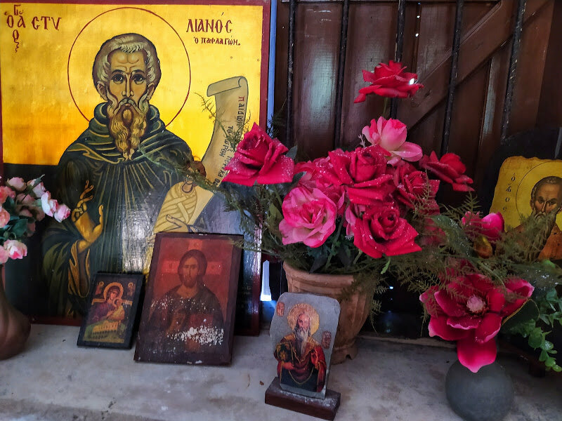 Иконы стоящие на окне церкви вместе с красными розами