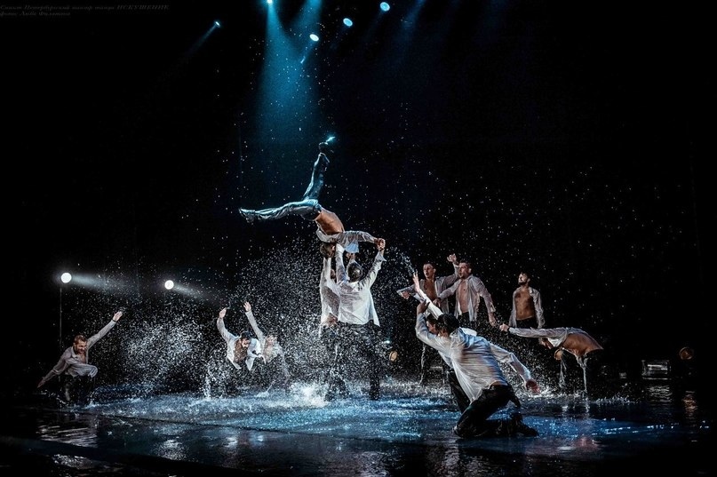 Танцующие мужчины в потоке дождя.